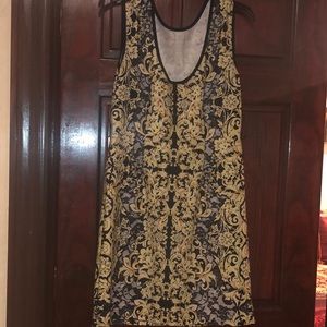Summer dress with gold and black background, black trim around the neck and arms